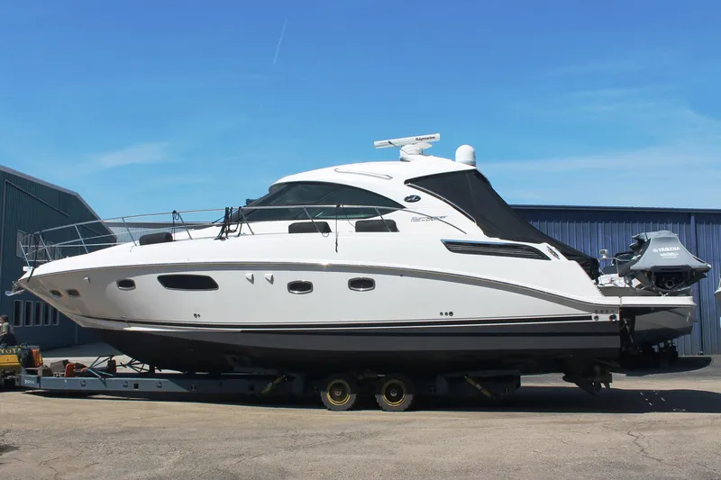  Yacht Photos Pics 2011 Sea Ray 470 Sundancer yacht on trailer, parked outdoors under clear blue sky.