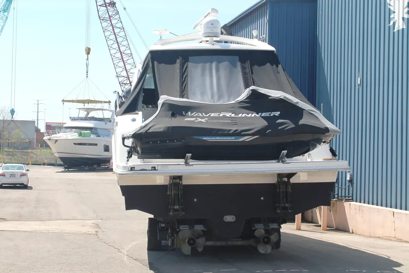  Yacht Photos Pics 2011 Sea Ray 470 Sundancer with a Waverunner, docked near a blue building.