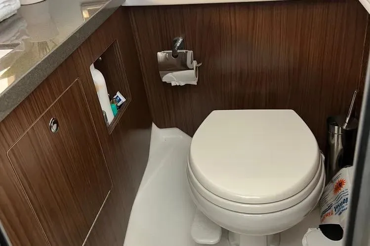  Yacht Photos Pics 2023 Four Winns H350 OB boat bathroom with wood paneling and modern fixtures.