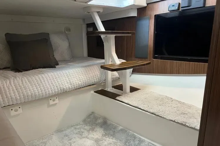  Yacht Photos Pics 2023 Four Winns H350 OB cabin interior with bed, stairs, and TV.