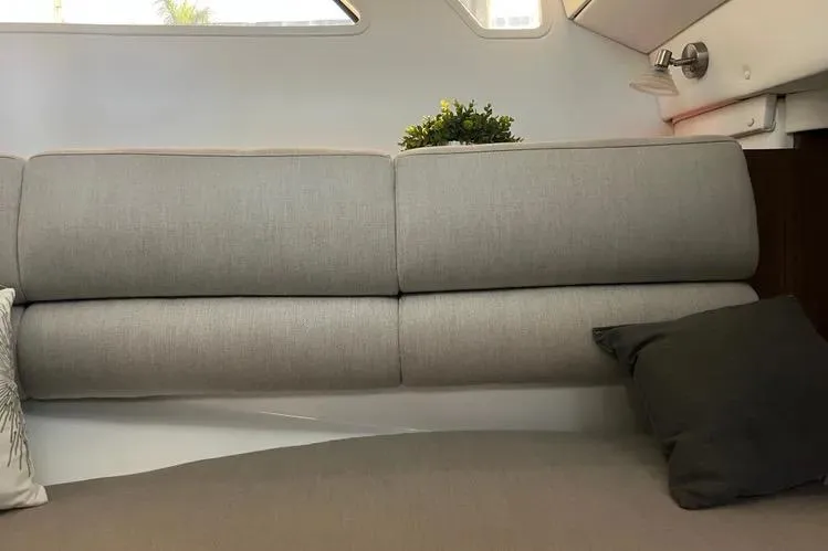  Yacht Photos Pics 2023 Four Winns H350 OB interior with gray cushioned seating and decorative pillows.