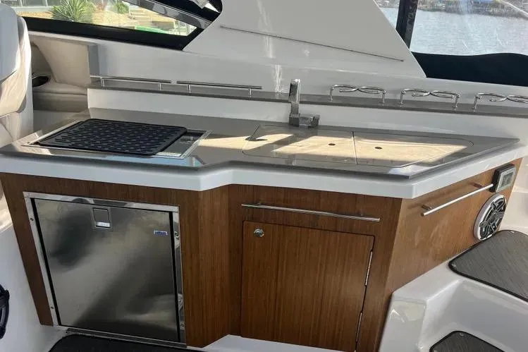  Yacht Photos Pics 2023 Four Winns H350 OB boat kitchenette with sink, grill, and storage.