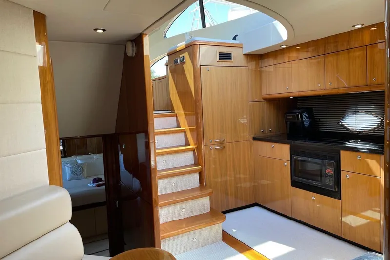 Relentless Yacht Photos Pics Luxurious interior of 2009 Sunseeker Predator 62 yacht with wooden cabinetry and modern kitchen.