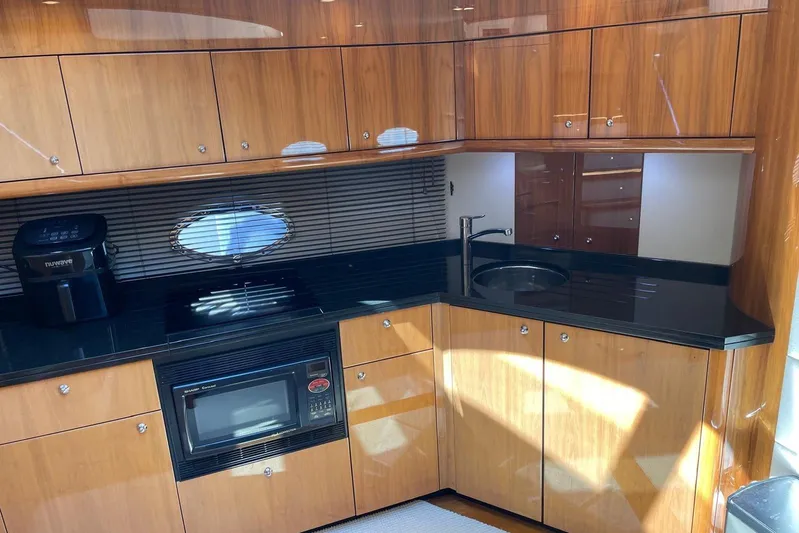 Relentless Yacht Photos Pics Luxurious 2009 Sunseeker Predator 62 yacht kitchen with sleek wood cabinetry and modern appliances.