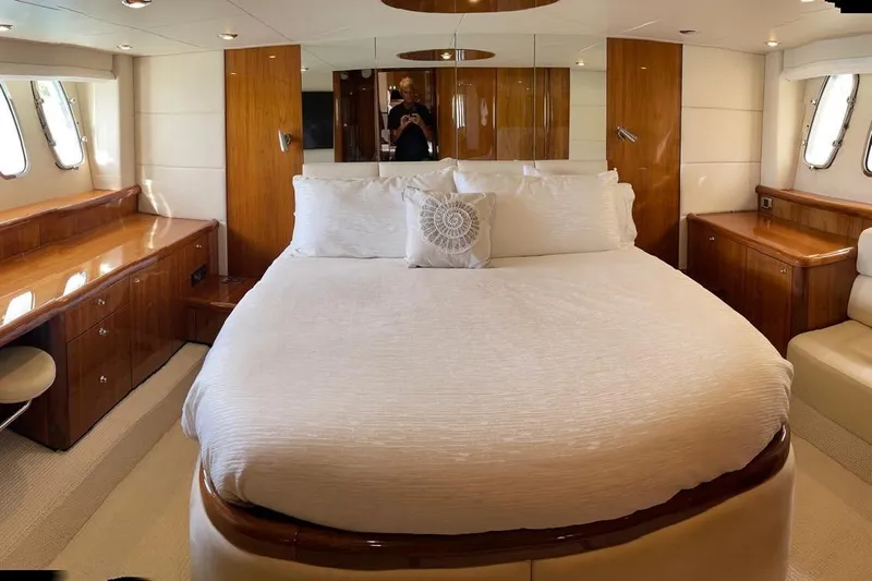 Relentless Yacht Photos Pics Luxurious bedroom interior of 2009 Sunseeker Predator 62 yacht with elegant wood finishes.