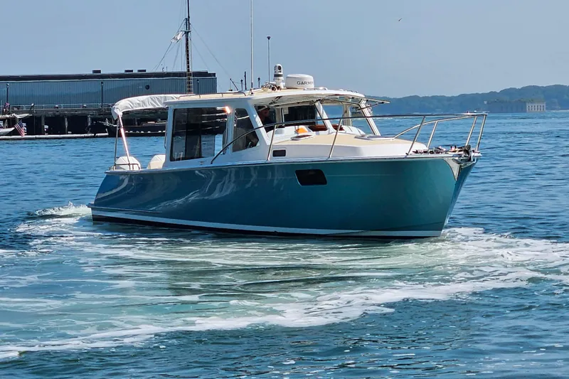 Sandora Yacht Photos Pics 2023 MJM 35 boat cruising on calm waters near a dock.