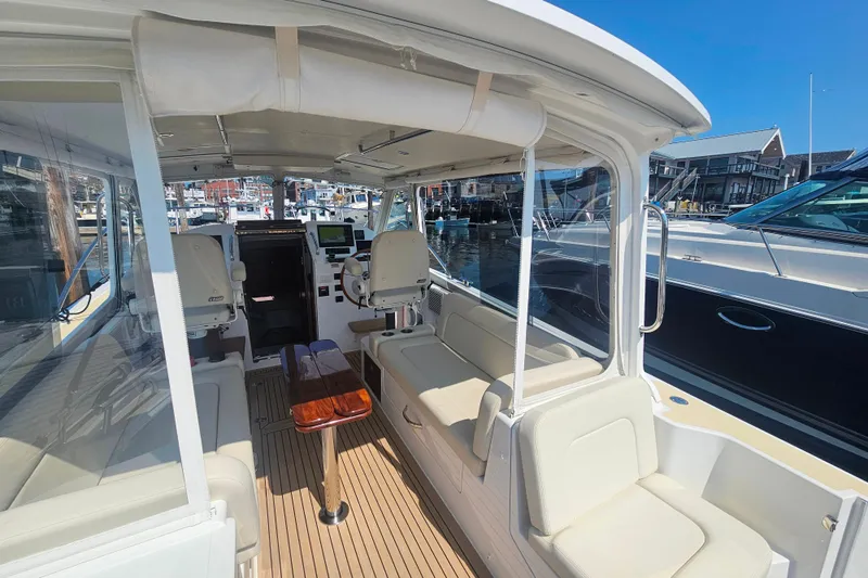 Sandora Yacht Photos Pics 2023 MJM 35 boat interior with seating, helm, and marina view.