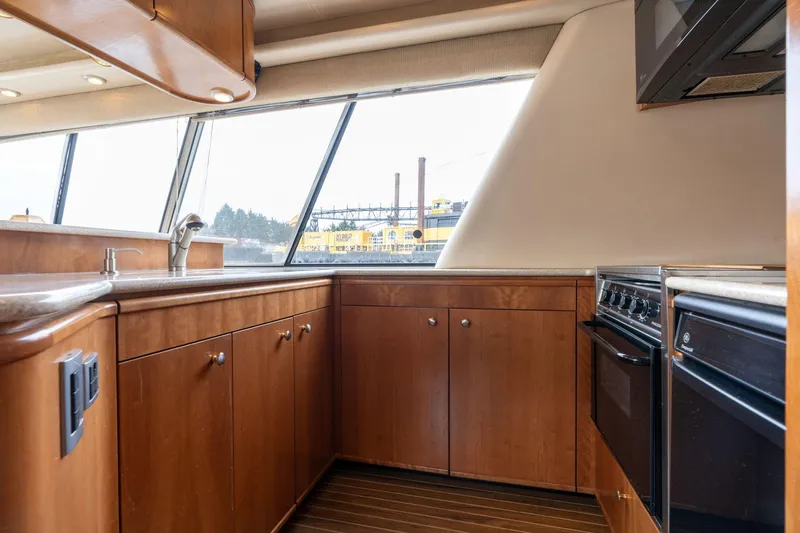 Candykiss Yacht Photos Pics Interior of 2003 Meridian 490 Pilothouse yacht kitchen with wood cabinets and modern appliances.