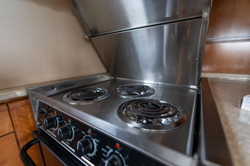 Candykiss Yacht Photos Pics Stainless steel stove with three burners in a 2003 Meridian 490 Pilothouse yacht kitchen.