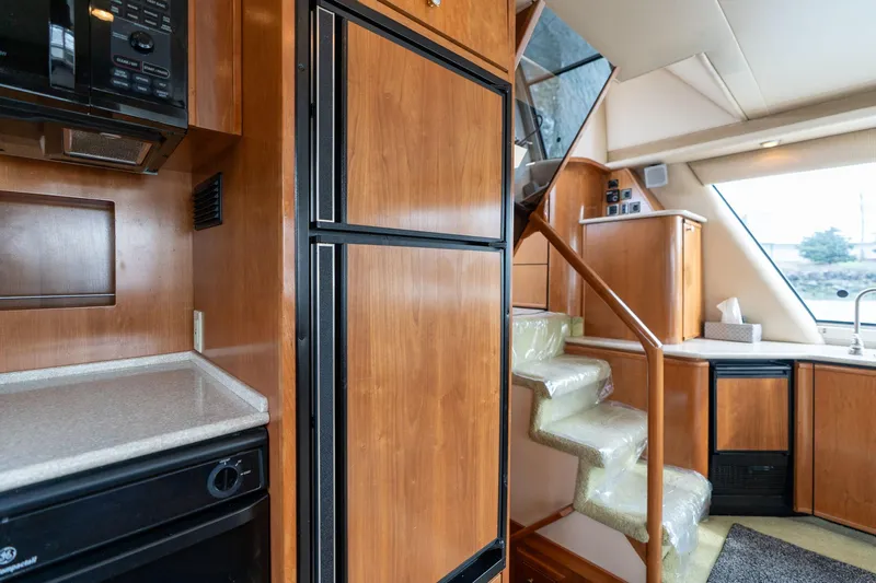 Candykiss Yacht Photos Pics Interior of 2003 Meridian 490 Pilothouse with wooden cabinetry and staircase.