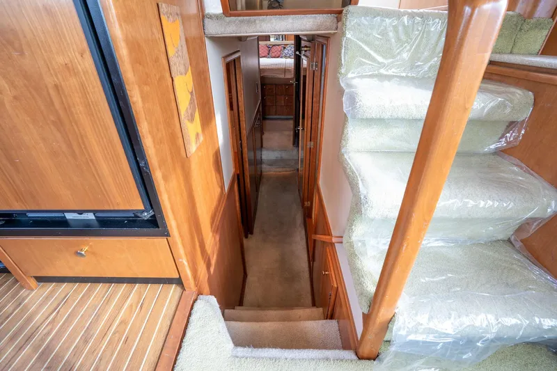 Candykiss Yacht Photos Pics Interior view of 2003 Meridian 490 Pilothouse yacht with carpeted stairs and wooden paneling.