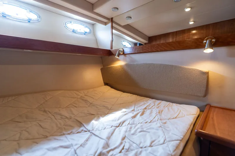 Candykiss Yacht Photos Pics Cozy cabin interior of 2003 Meridian 490 Pilothouse yacht with bed and portholes.