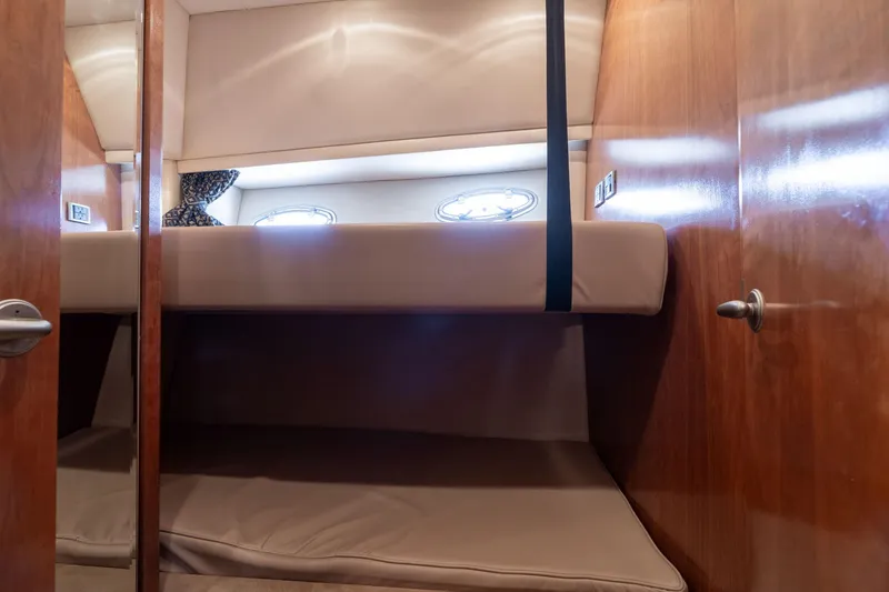 Candykiss Yacht Photos Pics Interior of 2003 Meridian 490 Pilothouse with cozy bunk beds and wooden paneling.