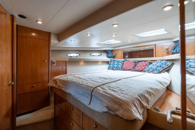 Candykiss Yacht Photos Pics Luxurious bedroom interior of 2003 Meridian 490 Pilothouse yacht with cozy bedding and wood accents.