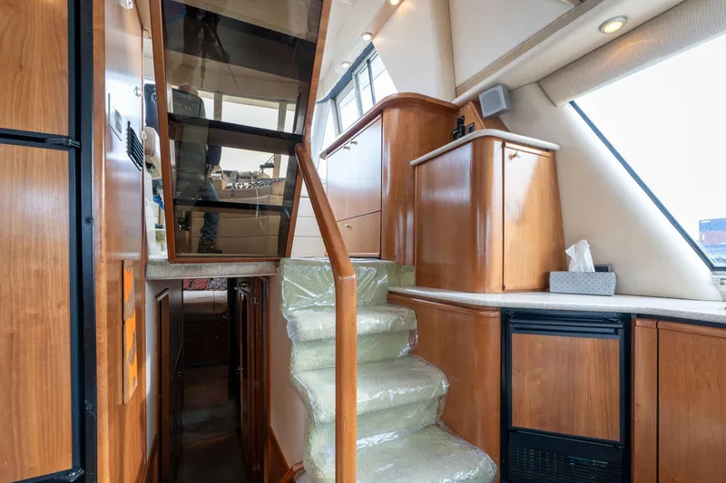Candykiss Yacht Photos Pics Interior of 2003 Meridian 490 Pilothouse with wooden cabinetry and carpeted stairs.
