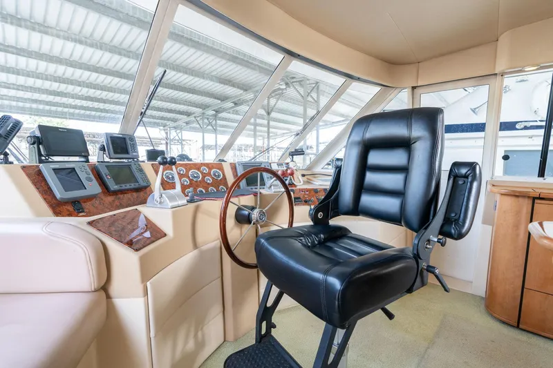 Candykiss Yacht Photos Pics Pilothouse interior of 2003 Meridian 490, featuring steering wheel and navigation instruments.