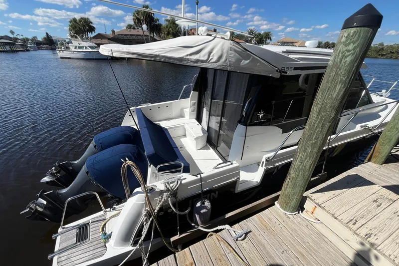 Iffin Yacht Photos Pics 2018 Jeanneau NC 895 boat docked by a wooden pier on a sunny day.