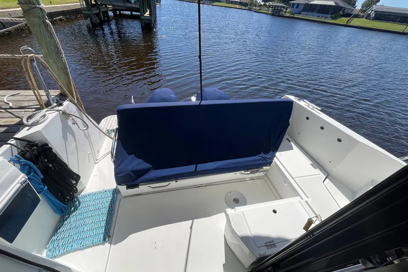 Iffin Yacht Photos Pics 2018 Jeanneau NC 895 boat deck with blue seating, docked by a calm river.