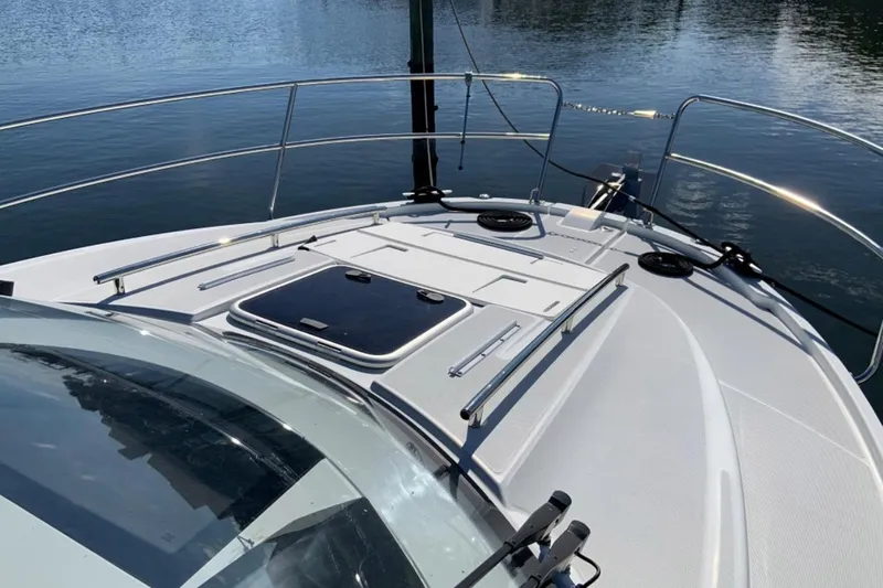 Iffin Yacht Photos Pics 2018 Jeanneau NC 895 boat deck with railing, hatch, and calm water backdrop.