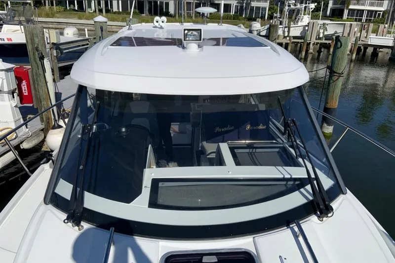 Iffin Yacht Photos Pics 2018 Jeanneau NC 895 boat docked at marina, front view with clear windshield.