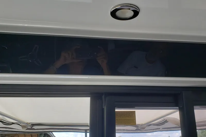 Iffin Yacht Photos Pics 2018 Jeanneau NC 895 boat interior with reflective window and ceiling light.
