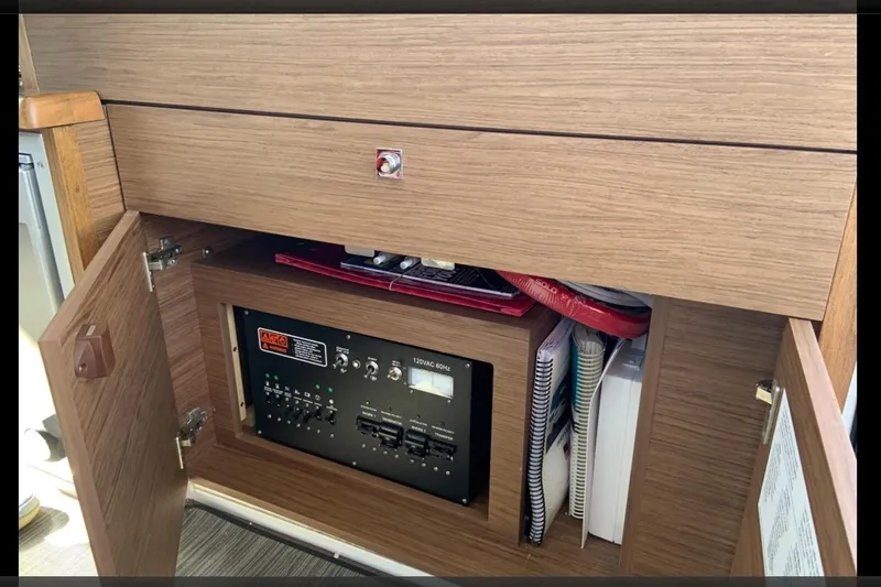 Iffin Yacht Photos Pics 2018 Jeanneau NC 895 electrical panel inside wooden cabinet with open doors.