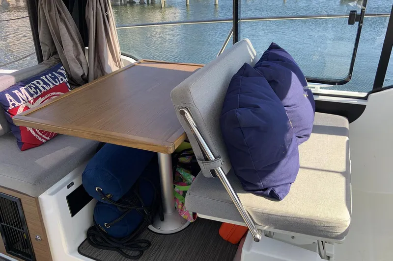 Iffin Yacht Photos Pics Interior of 2018 Jeanneau NC 895 boat with cushioned seating and table.