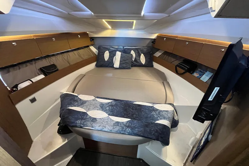 Iffin Yacht Photos Pics Interior cabin of 2018 Jeanneau NC 895 boat with cozy bedding and storage.