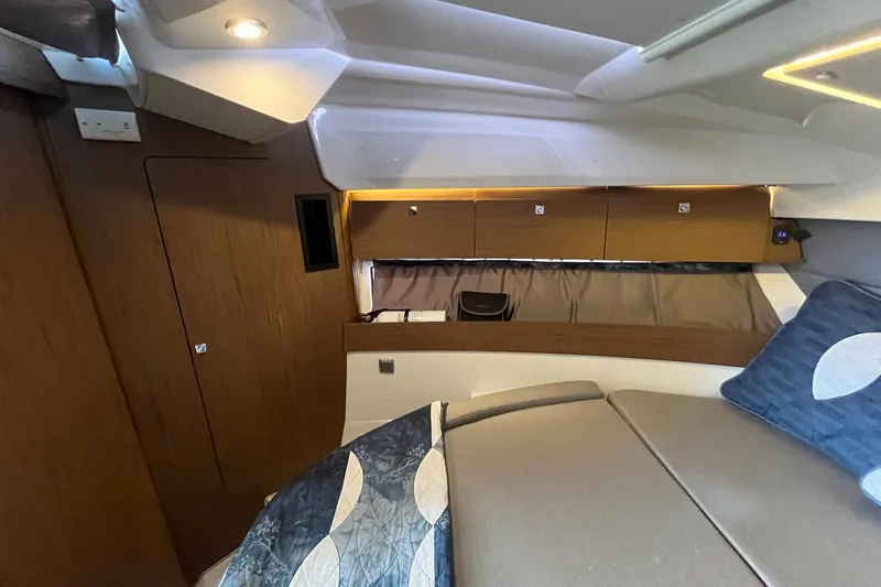 Iffin Yacht Photos Pics Interior cabin of 2018 Jeanneau NC 895 boat, featuring cozy bedding and wooden cabinetry.