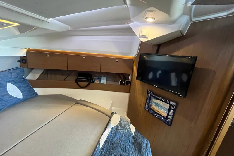 Iffin Yacht Photos Pics Interior of 2018 Jeanneau NC 895 boat with bed, TV, and storage cabinets.