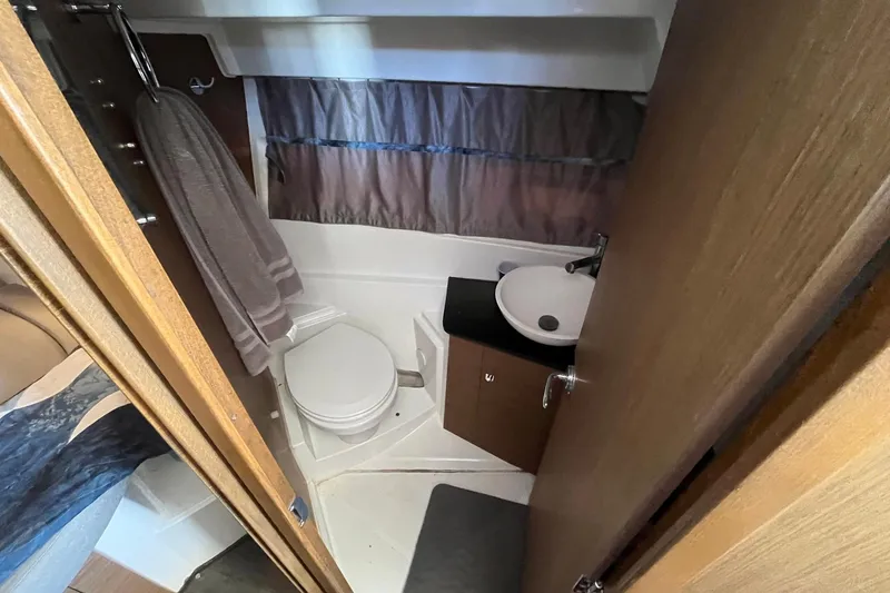 Iffin Yacht Photos Pics Compact bathroom in 2018 Jeanneau NC 895 boat with toilet, sink, and towel.