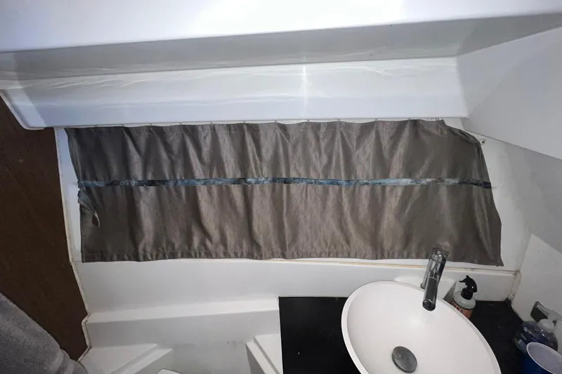 Iffin Yacht Photos Pics Bathroom interior of 2018 Jeanneau NC 895 boat with sink and curtain.