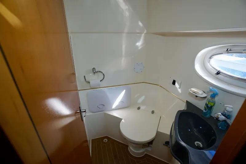 Fifth Day Yacht Photos Pics Bathroom interior of 2000 Venturer 44 yacht with toilet, sink, and porthole window.
