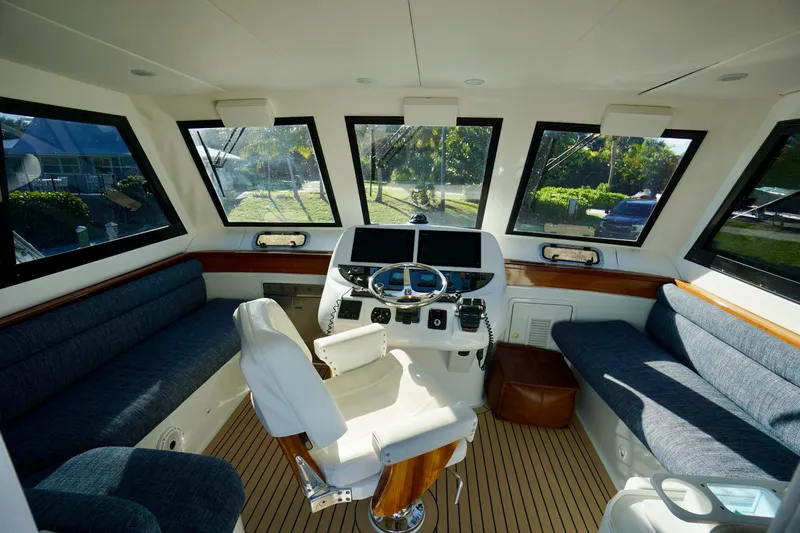 Fifth Day Yacht Photos Pics Interior of 2000 Venturer 44 yacht with helm, seating, and panoramic windows.