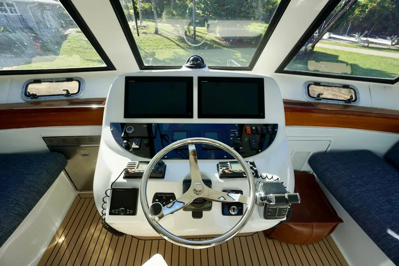 Fifth Day Yacht Photos Pics Cockpit of 2000 Venturer 44 boat with steering wheel and navigation screens.