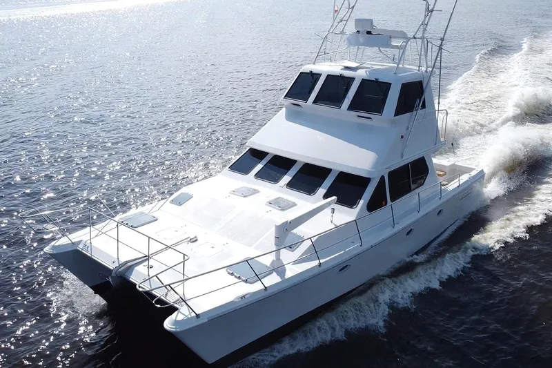 Fifth Day Yacht Photos Pics Luxurious 2000 Voyager 44 yacht cruising on open water, showcasing sleek design and elegance.