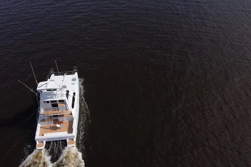 Fifth Day Yacht Photos Pics Aerial view of 2000 Voyager 44 yacht cruising on open water.