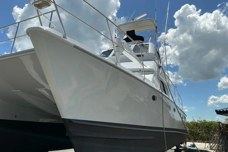 Fifth Day Yacht Photos Pics 2000 Voyager 44 yacht under a bright blue sky with clouds.