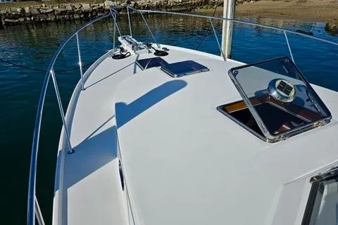 Maestro Yacht Photos Pics 2006 Lyman-Morse 38 Jet Boat deck with open hatch, docked by calm waters.