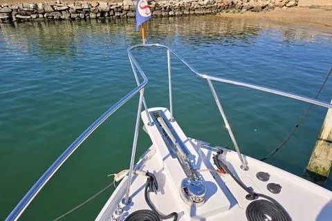 Maestro Yacht Photos Pics Bow view of 2006 Lyman-Morse 38 Jet Boat in calm waters near a rocky shore.