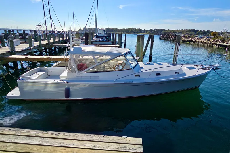 Maestro Yacht Photos Pics 2006 Lyman-Morse Monhegan 38 Twin Jet boat docked in a serene marina setting.