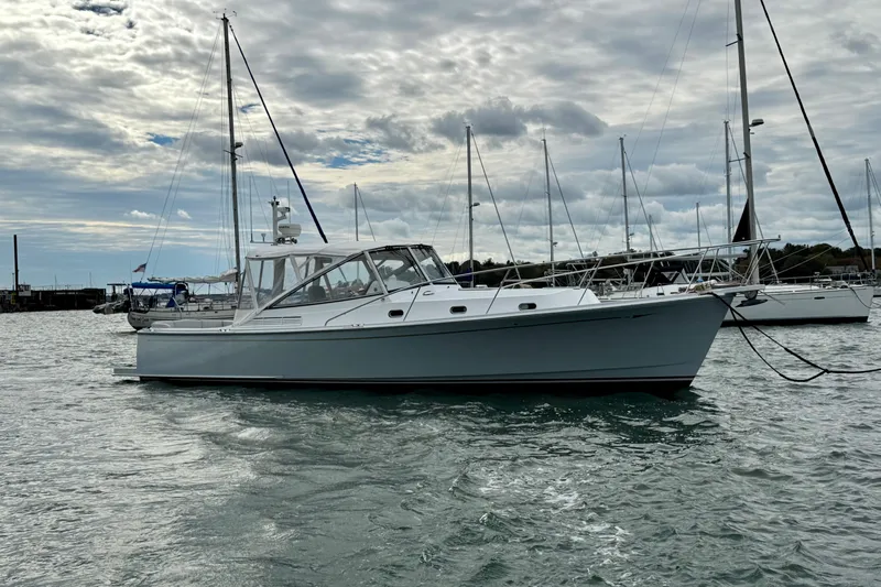 Maestro Yacht Photos Pics 2006 Lyman-Morse Monhegan 38 Twin Jet yacht docked in a marina under cloudy skies.