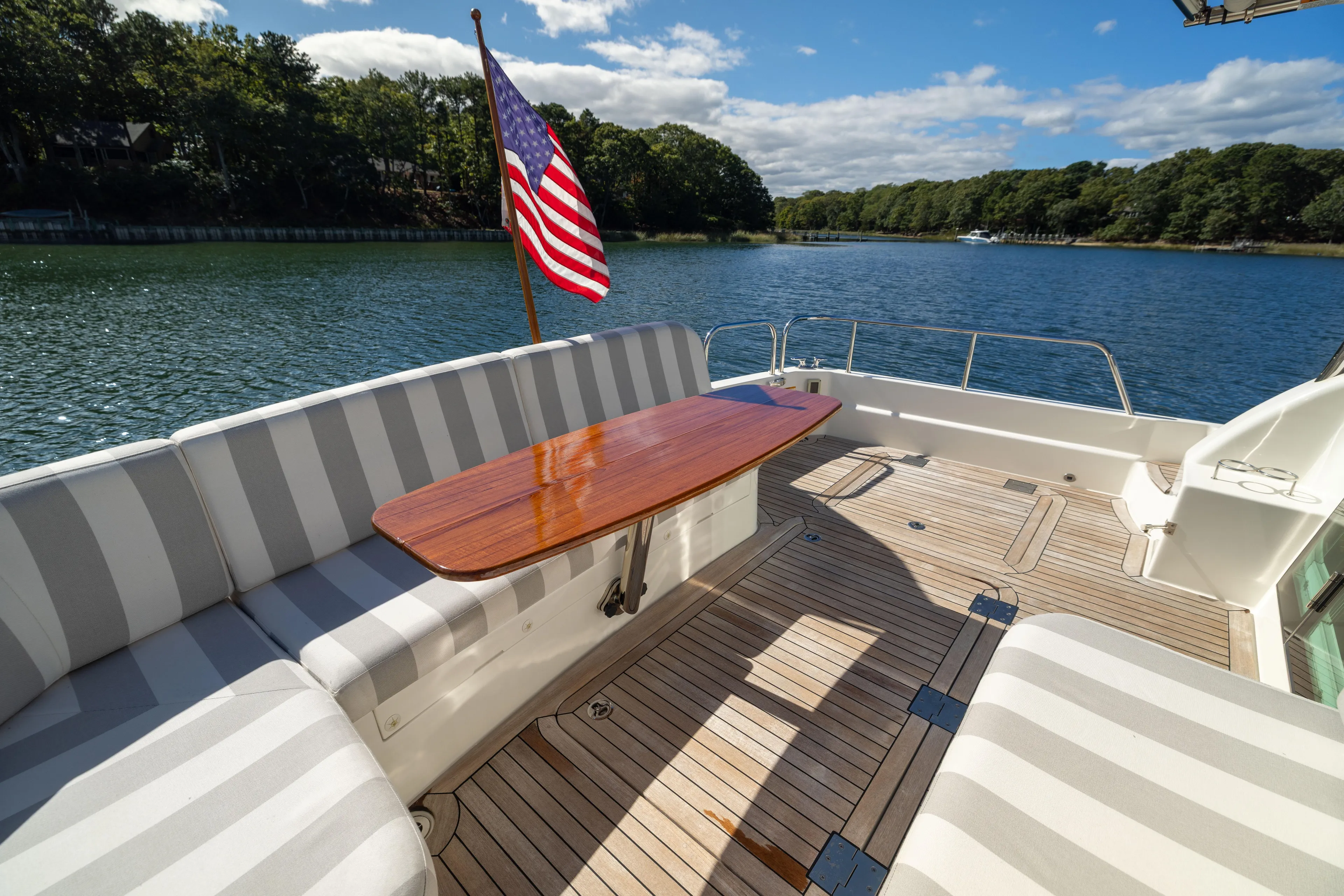  Yacht Photos Pics 2022 Sabre 48 Salon Express yacht deck with striped seating and American flag.