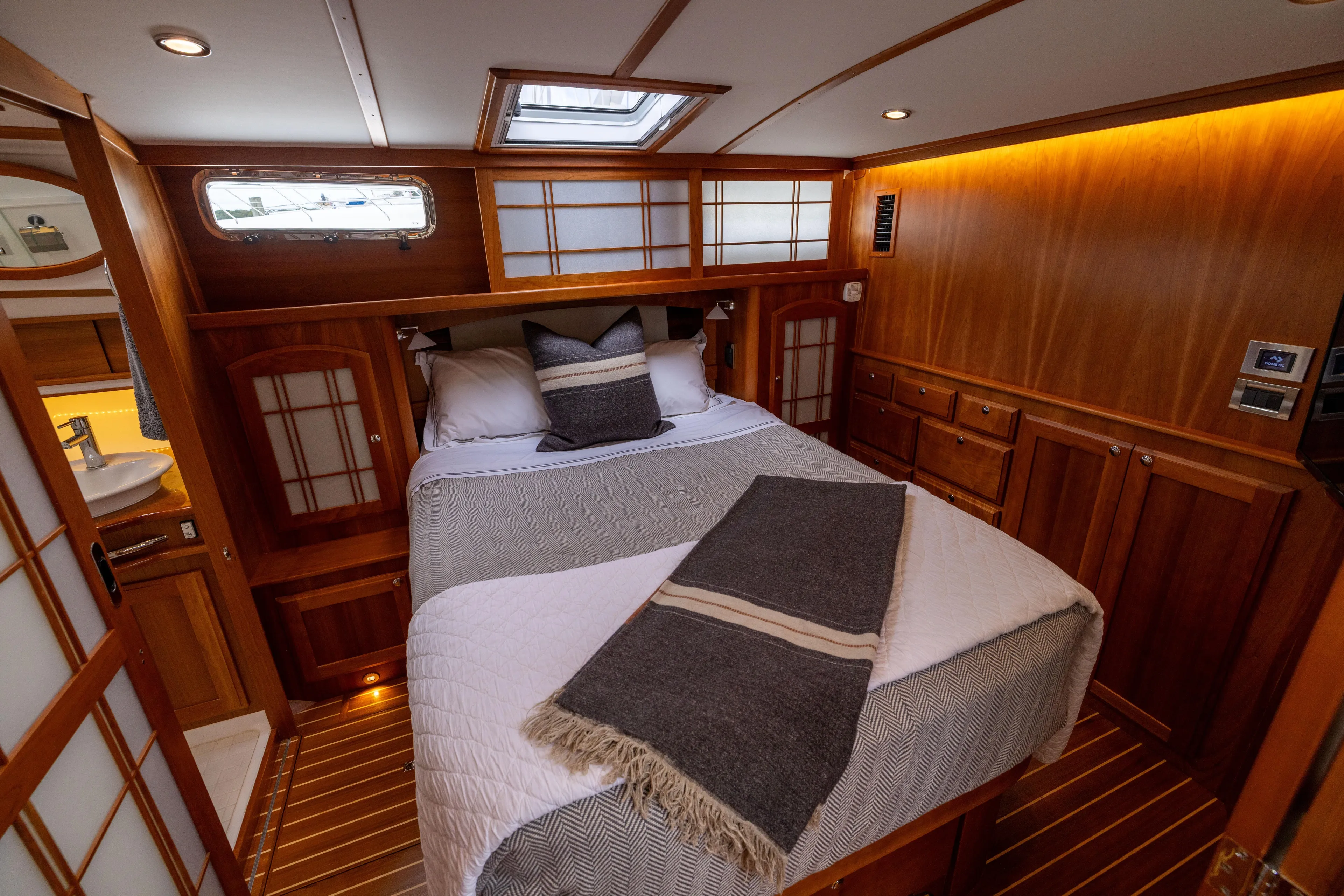  Yacht Photos Pics Luxurious 2022 Sabre 48 Salon Express cabin with elegant wood finish and cozy bedding.