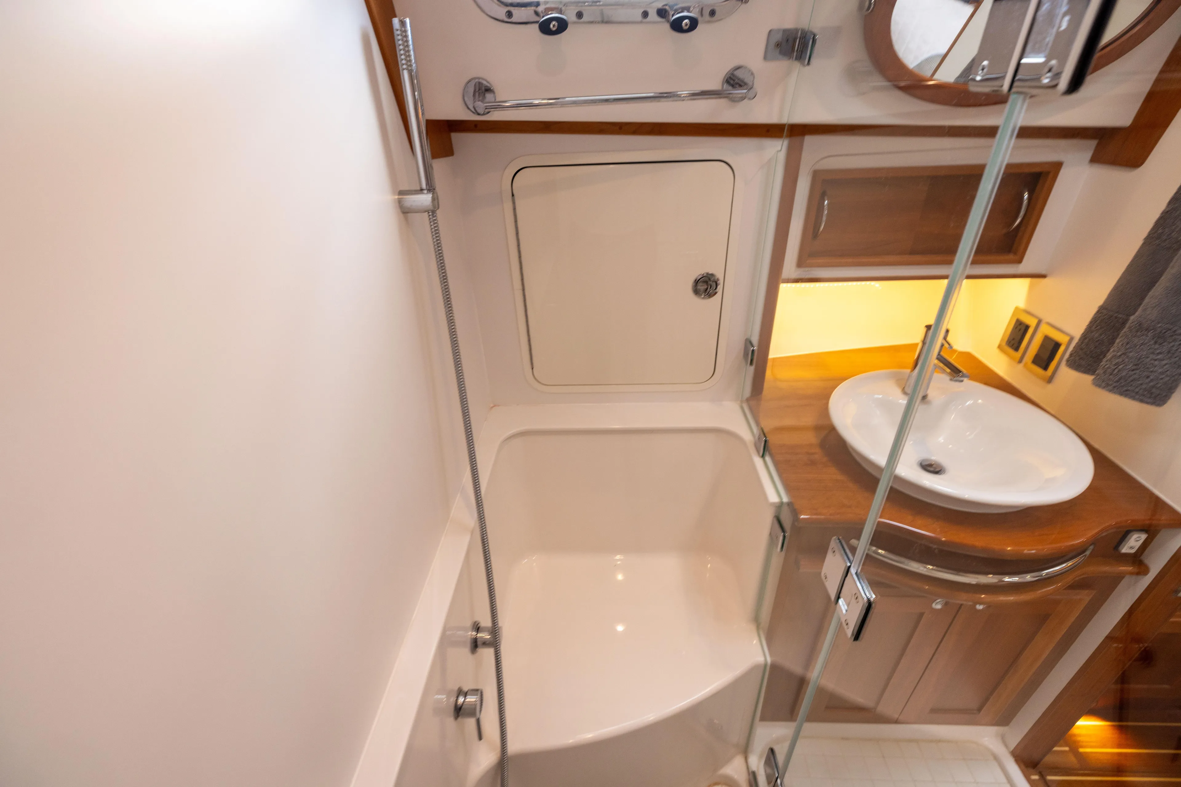  Yacht Photos Pics 2022 Sabre 48 Salon Express bathroom with shower, sink, and wooden cabinetry.