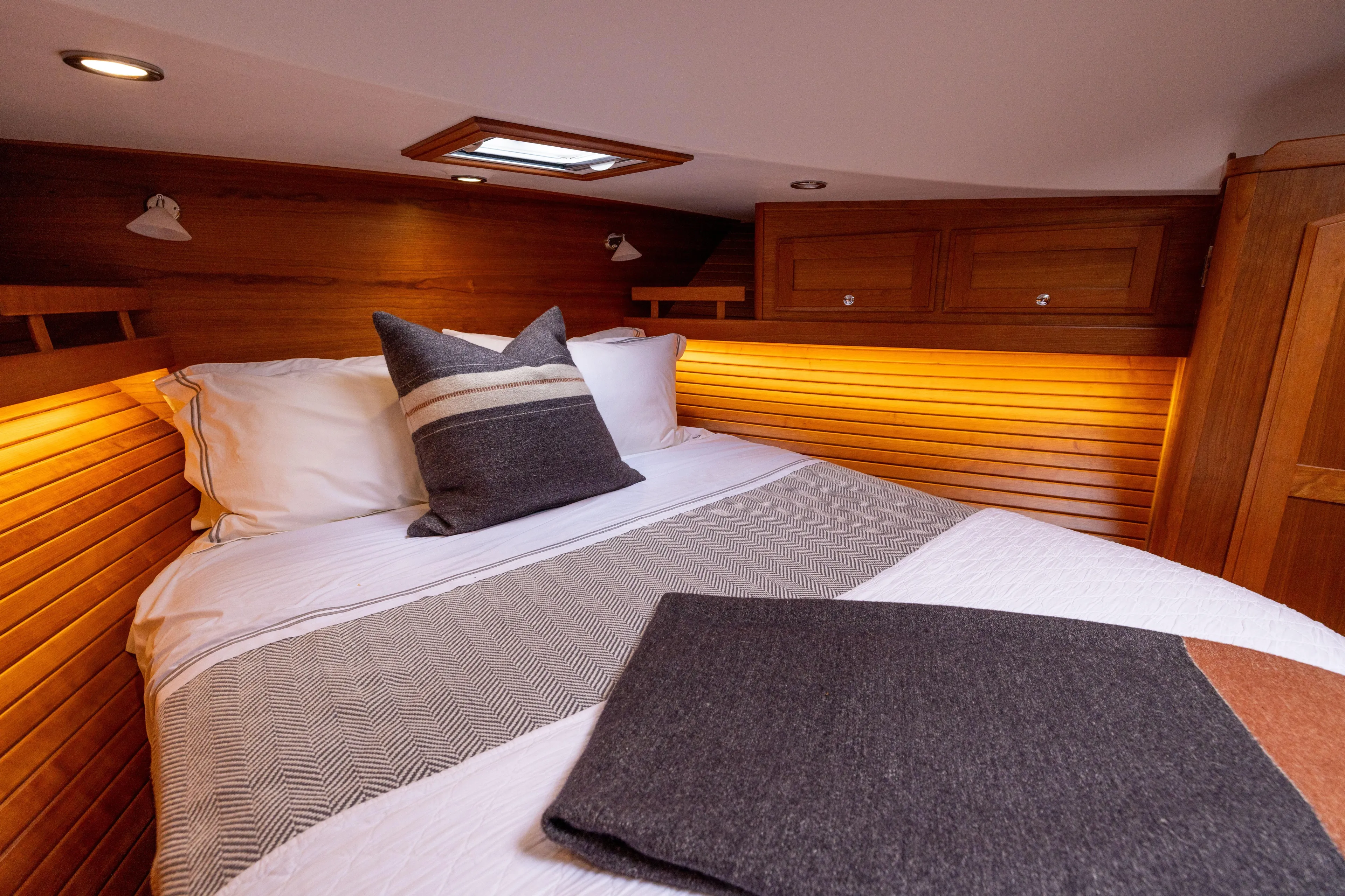  Yacht Photos Pics Cozy bedroom interior of 2022 Sabre 48 Salon Express yacht with wooden accents.