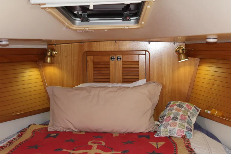 Cuckoo's Nest II Yacht Photos Pics Cozy cabin interior of a 2002 Catalina MkII sailboat with wooden paneling and bedding.