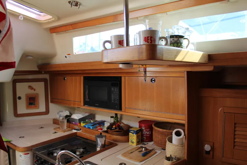 Cuckoo's Nest II Yacht Photos Pics Interior of a 2002 Catalina MkII sailboat kitchen with wooden cabinets and modern appliances.