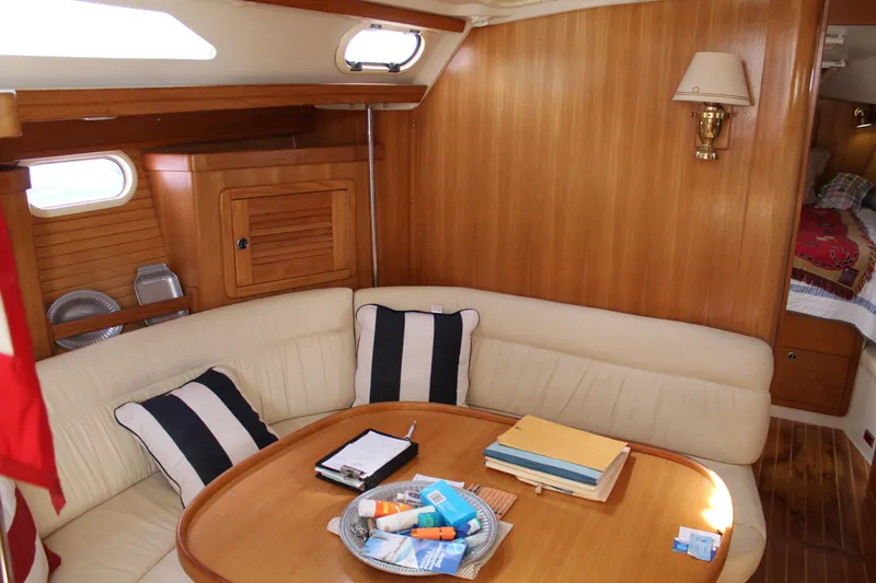 Cuckoo's Nest II Yacht Photos Pics Cozy interior of 2002 Catalina MkII sailboat with wooden paneling and cushioned seating.