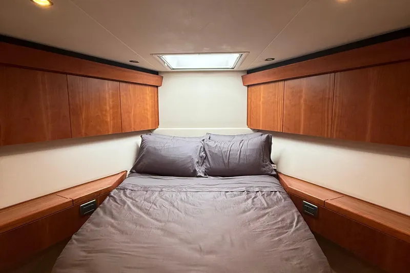  Yacht Photos Pics Luxurious bedroom interior of 2013 Hatteras GT54 yacht with wooden cabinets and skylight.
